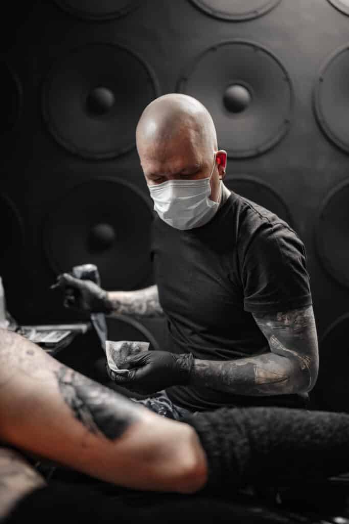 Tatuointitartisti Jari Kajaste työskentelemässä asiakkaan tatuoinnin parissa.